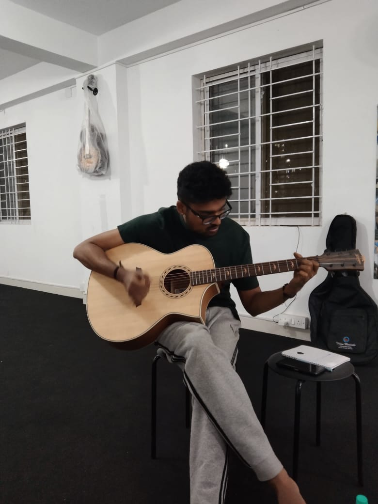 Teacher encouraging a student during guitar practice