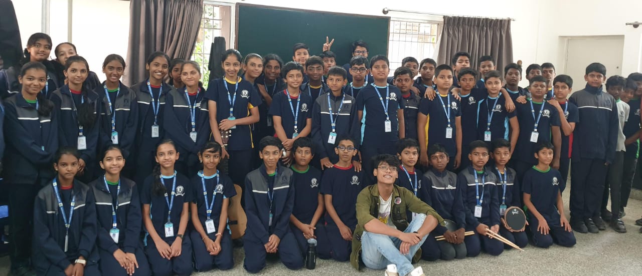 Graduation photo of students holding certificates and guitars